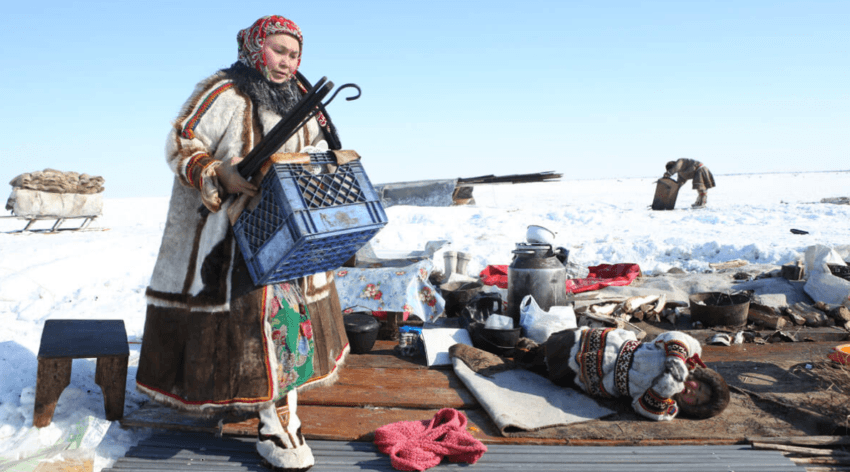 Kobieta z plemienia pakuje rzeczy, przygotowując się do kolejnej migracji